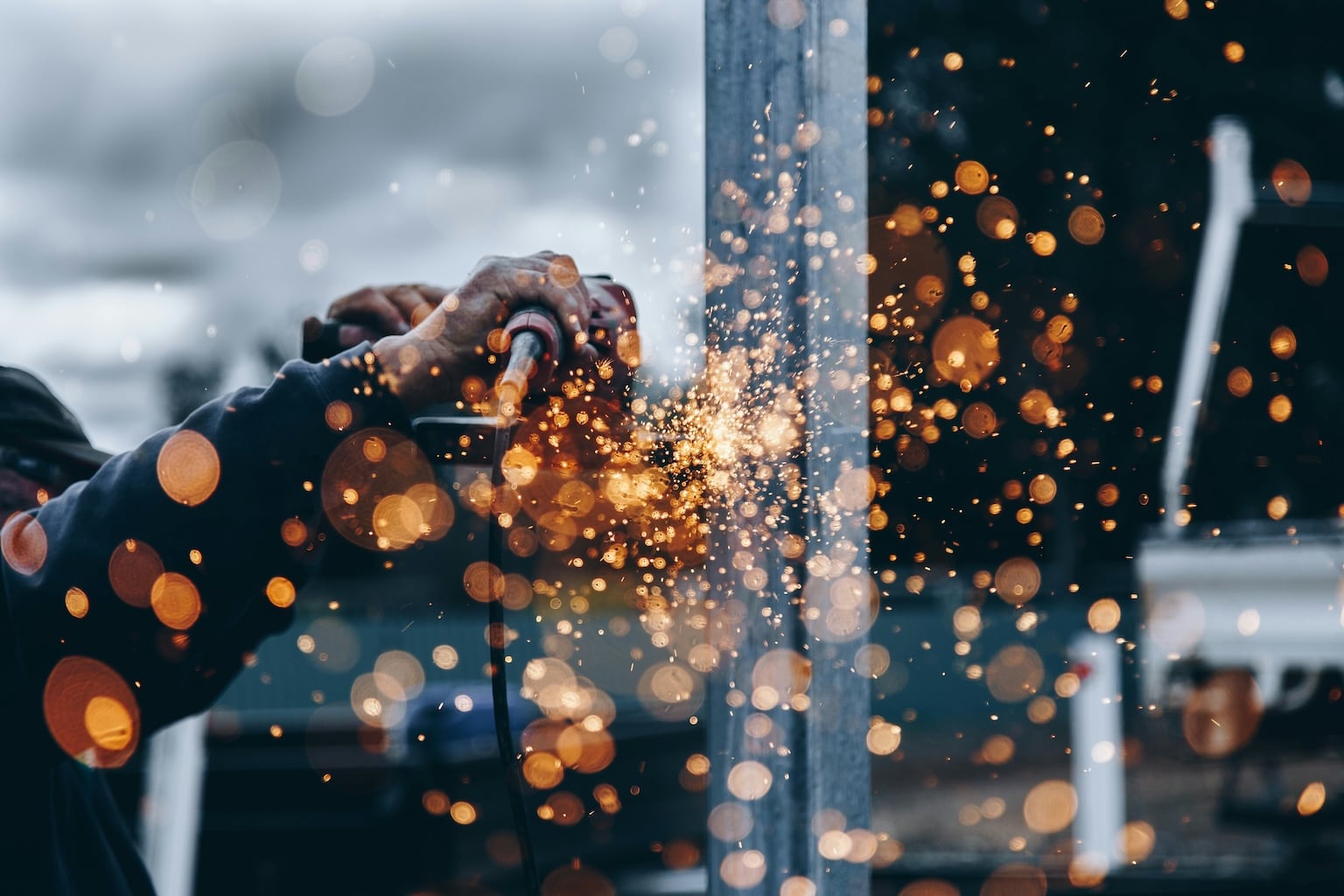Travailleur utilisant une meuleuse avec projections d’étincelles, illustrant les risques maîtrisés par un PPSPS sur chantier